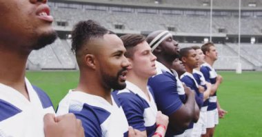 Çeşitli erkek rugby oyuncuları stadyumda birlikte yemin ediyorlar. 4k 'ı gözden kaçırıyorlar.