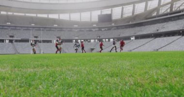 Stadyumda rugby oynayan çeşitli rugby oyuncularının ön görüntüsü. Erkek oyuncu yere atlıyor. 4K