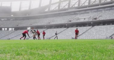 Stadyumda rugby oynayan çeşitli rugby oyuncularının ön görüntüsü. Erkek oyuncu yere atlıyor. 4K