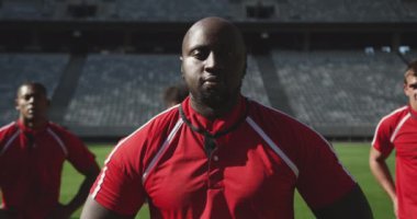 Afrika kökenli Amerikalı erkek rugby oyuncusunun yakın çekimi. Stadyumda elleri kalçasında duruyor. Yorgun ve kamera 4K 'ye bakıyor.