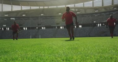 Stadyumda rugby oynayan farklı rugby oyuncularının düşük açılı görüntüsü. Birbirlerine 4k koşuyorlar.