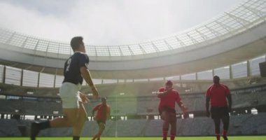 Stadyumda rugby oynayan farklı rugby oyuncularının düşük açılı görüntüsü. Birbirlerine 4k koşuyorlar.