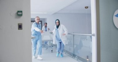 Bir grup doktorun hastayı acil bir durumda koridor boyunca hastane yatağında koşarken yavaş çekimde çekimleri. 