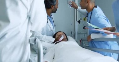Düşük açılı el kamerası, bir grup farklı doktorun hastane yatağında dikilirken yakın plan çekimleri..