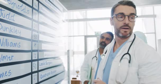 Çeşitli Doktorlardan Oluşan Bir Grup Beyaz Tahtada Hasta Ameliyatlarını Tartışıyor — Stok video