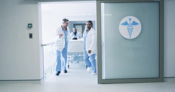 在医院的病床上 一群各种各样的医生在急诊室的走廊边冲着一位病人 慢动作 — 图库视频影像