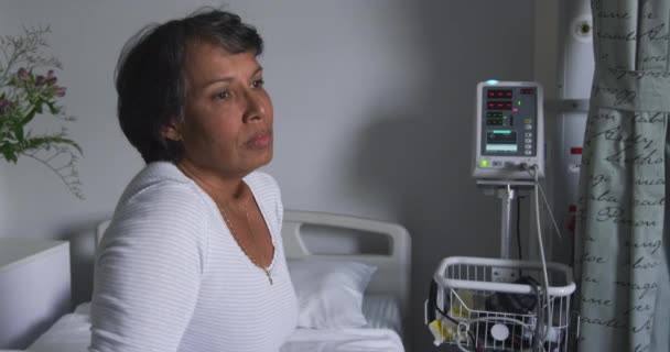 Bir Hastane Koğuşunda Yatakta Oturan Endişeli Yaşlı Melez Bir Kadının — Stok video