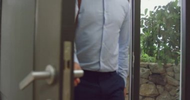 Beyaz baba, eve girerken iki çocuğunu kucaklıyor. Onlar 4k gülümsüyor