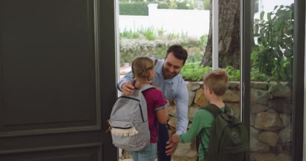 快適な家のドアで子供たちを抱きしめる白人の父親の正面図 笑顔で4K — ストック動画