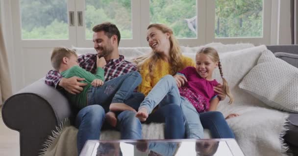 快適な家で楽しんでいる白人の家族の正面図 ソファ4Kに座っている — ストック動画