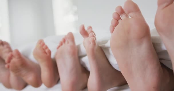 Gros Plan Des Pieds Famille Caucasienne Sous Couverture Sur Lit — Video