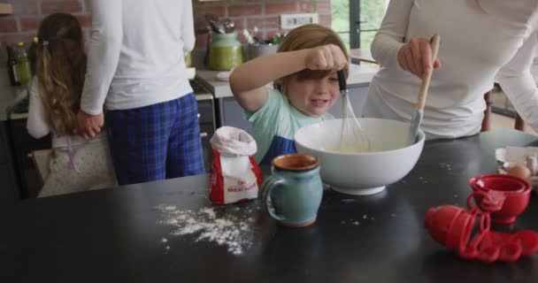 白人の母と息子が自宅のキッチンでワークトップにクッキーを準備する正面図 小麦粉4Kをかき混ぜる — ストック動画