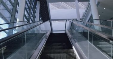 Ofis lobisinde yükselen modern yürüyen merdivenin düşük açılı görüntüsü.