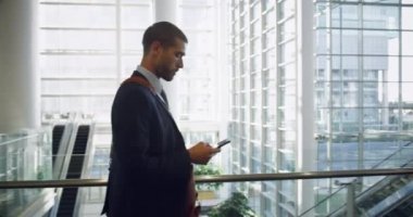 Ofiste yürürken iş adamının cep telefonuyla konuşmasının yan görüntüsü.
