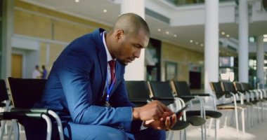 Ofisteki lobide konuşma pratiği yapan Afrikalı Amerikalı iş adamının yan görüntüsü. Cep telefonu kullanıyor. 