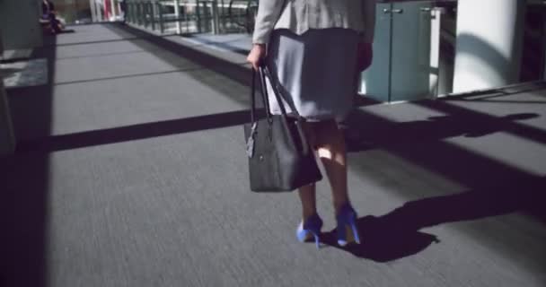オフィスの廊下を歩く女性の低いセクション 彼女はハンドバッグを持っています4K — ストック動画