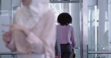 Modern ofisteki asansöre binen Afro-Amerikan iş adamları. Birbirleriyle etkileşim halindeler. 