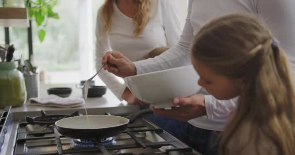 白种人家庭在家厨房准备食物的侧视图 父亲在锅4K中浇注成分 — 图库视频影像