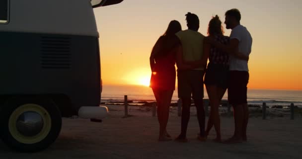 一个多民族的年轻成年朋友的全长后视图 在日落时分站在海滩上 由他们的露营车交谈 夏季日落党在海滩上与朋友有乐趣4K — 图库视频影像