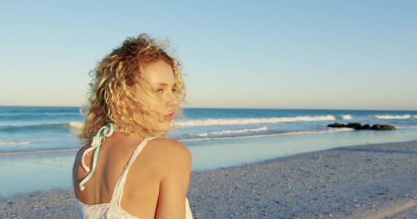 해변에 서있는 여성의 초상화를 그녀의 머리카락 4K를 흔들어 보입니다 — 비디오