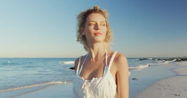 海辺のビーチを歩く若い白人女性の正面図をクローズアップ — ストック動画