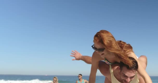 Close Young Adult Caucasian Couple Having Fun Piggybacking Beach Friends — Stock Video