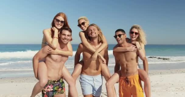 Portret Wieloetnicznej Grupy Sześciu Szczęśliwych Młodych Dorosłych Przyjaciół Piggybacking Plaży — Wideo stockowe