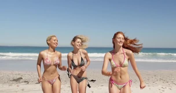 ビーチで走り 腕を上げている3人の若い成人女性の友人の多民族グループの正面図 一緒にビーチで夏の楽しみを持っている若い友人4K — ストック動画