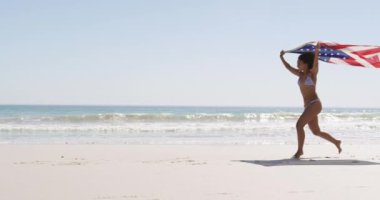Bir Plaj boyunca çalışan ve 4k atlama genç bir Afro-Amerikan kadın tam uzunlukta yan görünümü