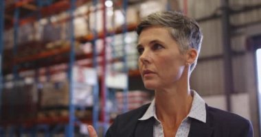 Orta yaşlı beyaz bir kadın depo müdürünün, bir genelevin yükleme bölümünde bir panoya yazı yazışının ön görüntüsünü kapatın. Nakliye ve dağıtım deposunda çalışıyorlar. Endüstriyel ve endüstriyel işçiler kavramı 4k