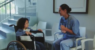 Kafkasyalı kadın doktorun hastanenin koridorunda engelli bir çocukla etkileşime girdiği görülüyor. Gülümsüyorlar.