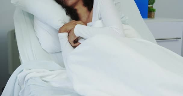 病棟のベッドで寝ているアフリカ系アメリカ人女性の正面図 彼女は4K移動しています — ストック動画