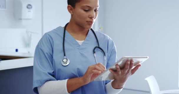 非洲裔美国女医生在医院使用数码平板电脑的前景 她笑着看着镜头下的4K — 图库视频影像