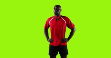 Genç bir Afrikalı Amerikalı rugby oyuncusunun canlandırması. Elleri kalçasının üzerinde, parlak yeşil bir arka planda duruyor. 4K