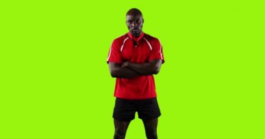 Genç bir Afrikalı Amerikalı rugby oyuncusunun canlandırması kolları çapraz duran parlak yeşil arka planda 4k