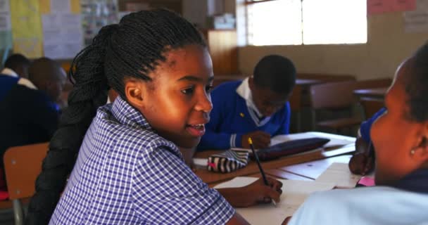 Вид Сбоку Запечатлел Двух Молодых Африканских Школьниц Сидящих Своим Столом — стоковое видео