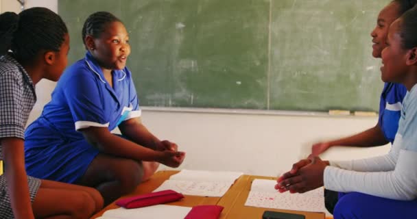 一组年轻的非洲女学生在小城镇小学4K课间休息时玩耍和聊天的侧视图 — 图库视频影像
