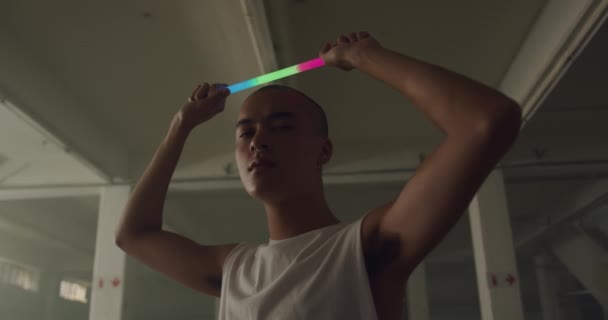 Portrait Hip Young Mixed Race Man Empty Warehouse Holding Glowstick — Stock Video