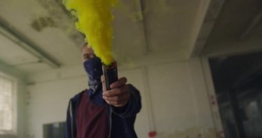 Boş bir depoda bir kalça genç karışık ırk adam Yan görünümü, bandana yüzünü kaplayan bir el bombası tutan