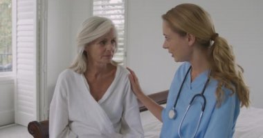 Bir hastanede kötü haber ve genç Kafkas kadın doktor alan endişeli bir üst düzey Kafkas kadın ve ön görünüm yakın