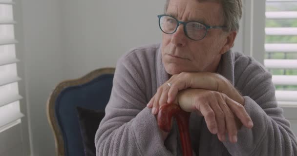 Вид Сбоку Вдумчивого Пожилого Белого Мужчину Очках Чтения Опирающегося Трость — стоковое видео