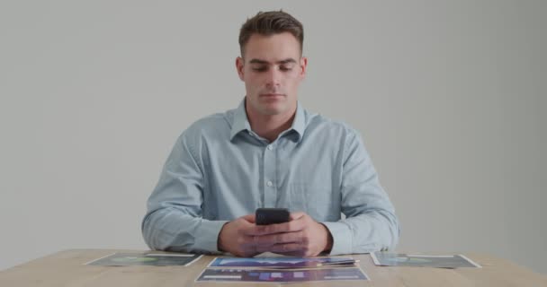 Vista Frontal Cerca Joven Caucásico Sentado Una Mesa Usando Teléfono — Vídeo de stock