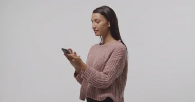 Bir akıllı telefon kullanarak duran, konuşan ve gülümseyen genç bir Kafkas adam yan görünümü yakın