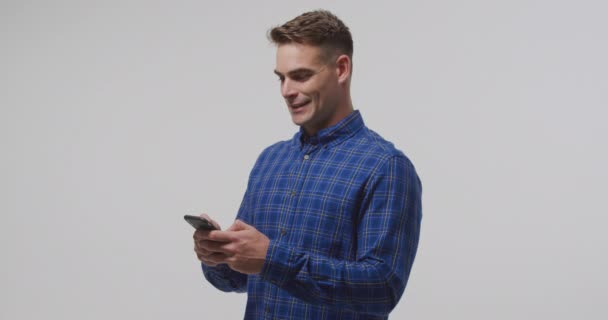 Vista Lateral Perto Jovem Caucasiano Usando Smartphone Sorrindo — Vídeo de Stock