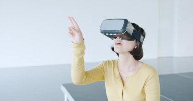 Modern bir ofiste VR gözlük takan gülümseyen Asyalı genç bir kadının ön görüntüsü.