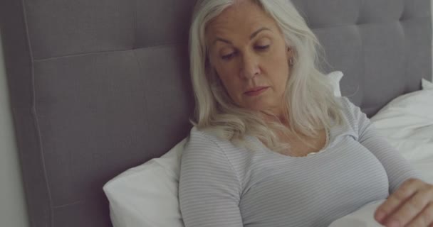 心配した白人女性がベッドでリクライニングして薬を飲むのが心配の側面図クローズアップ — ストック動画