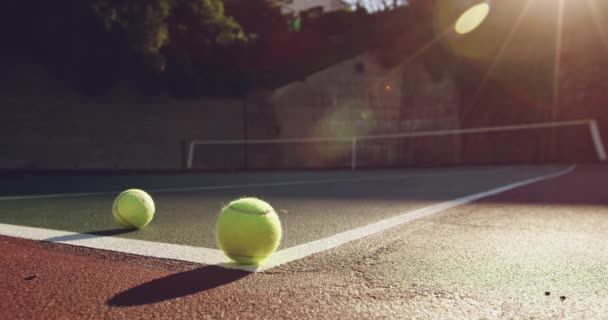 Güneşli Bir Tenis Kortundan Yuvarlanan Iki Tenis Topunun Yakın Çekim — Stok video