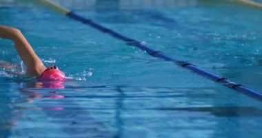 Front view of young female swimmers training in a swimming pool, crawl