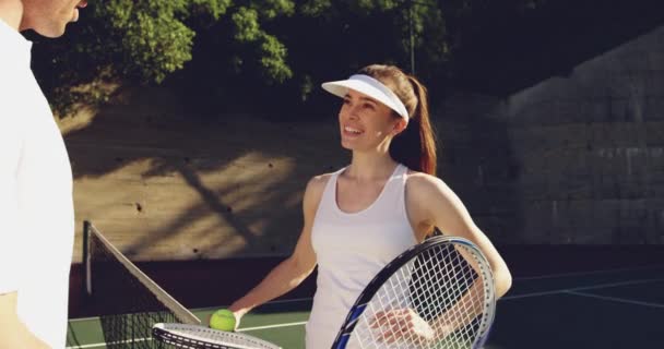 若い白人女性とコートでテニスをしている若い白人男性の側面図クローズアップ ネット上で話す — ストック動画