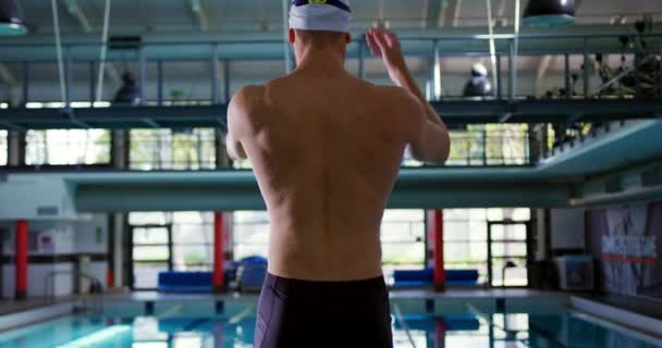 一个年轻的白种男性游泳者在游泳池边伸展的后视图 — 图库视频影像